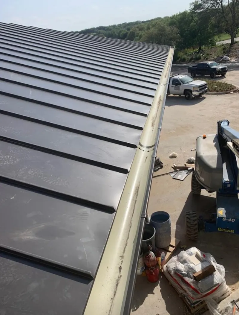 Standing seam panel and gutter detail on a metal roofing jobsite in Alice